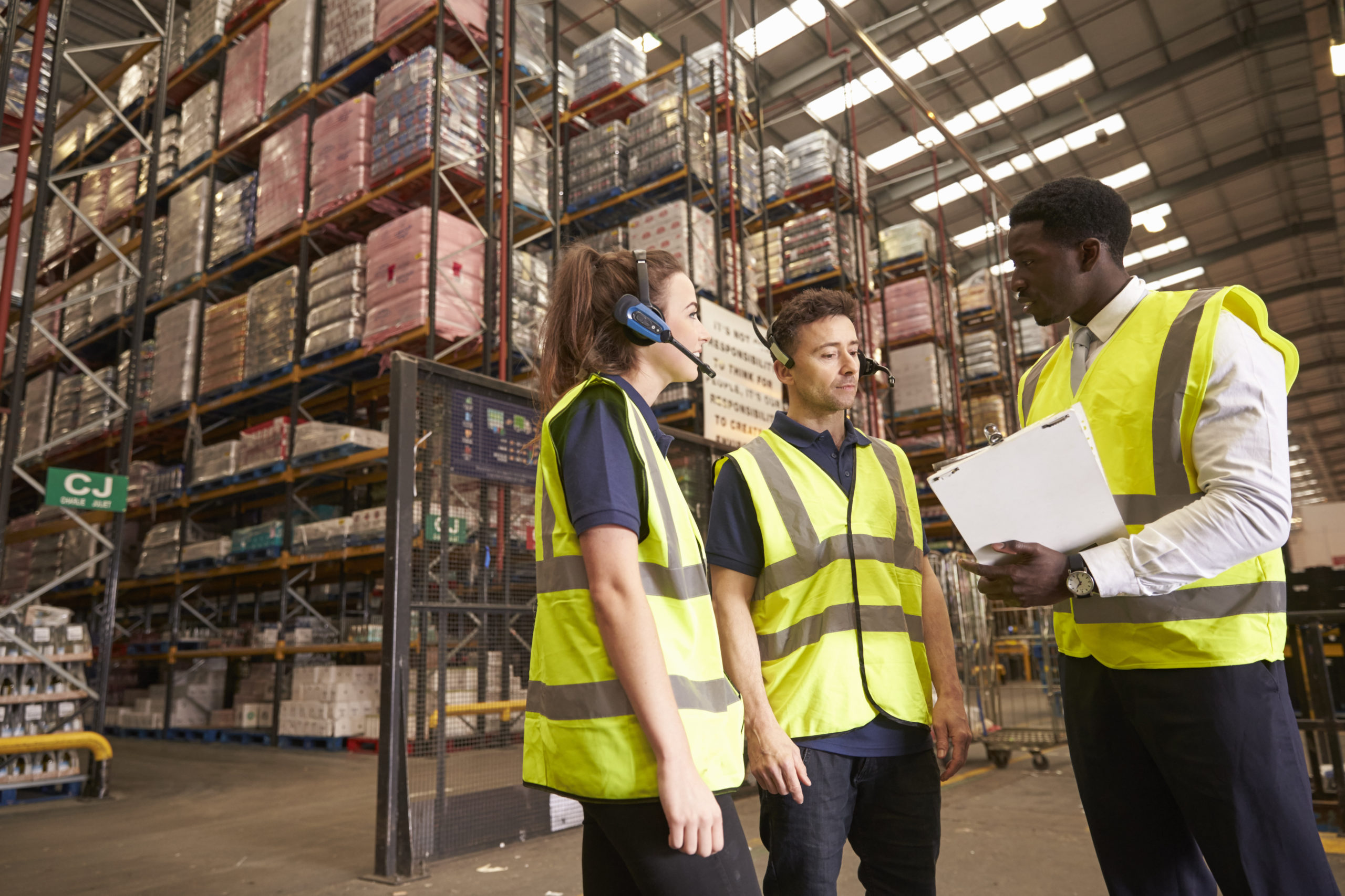 Manufactures in a warehouse wearing safety vests